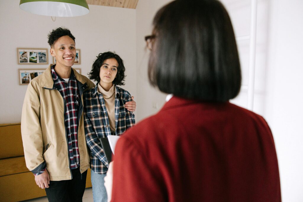 Couple Standing In Front of Real Estate Agent